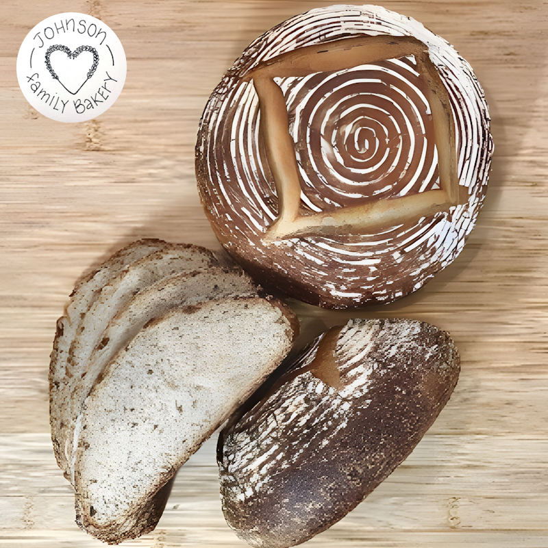 An artisinal loaf of bread beside a stack of slices.